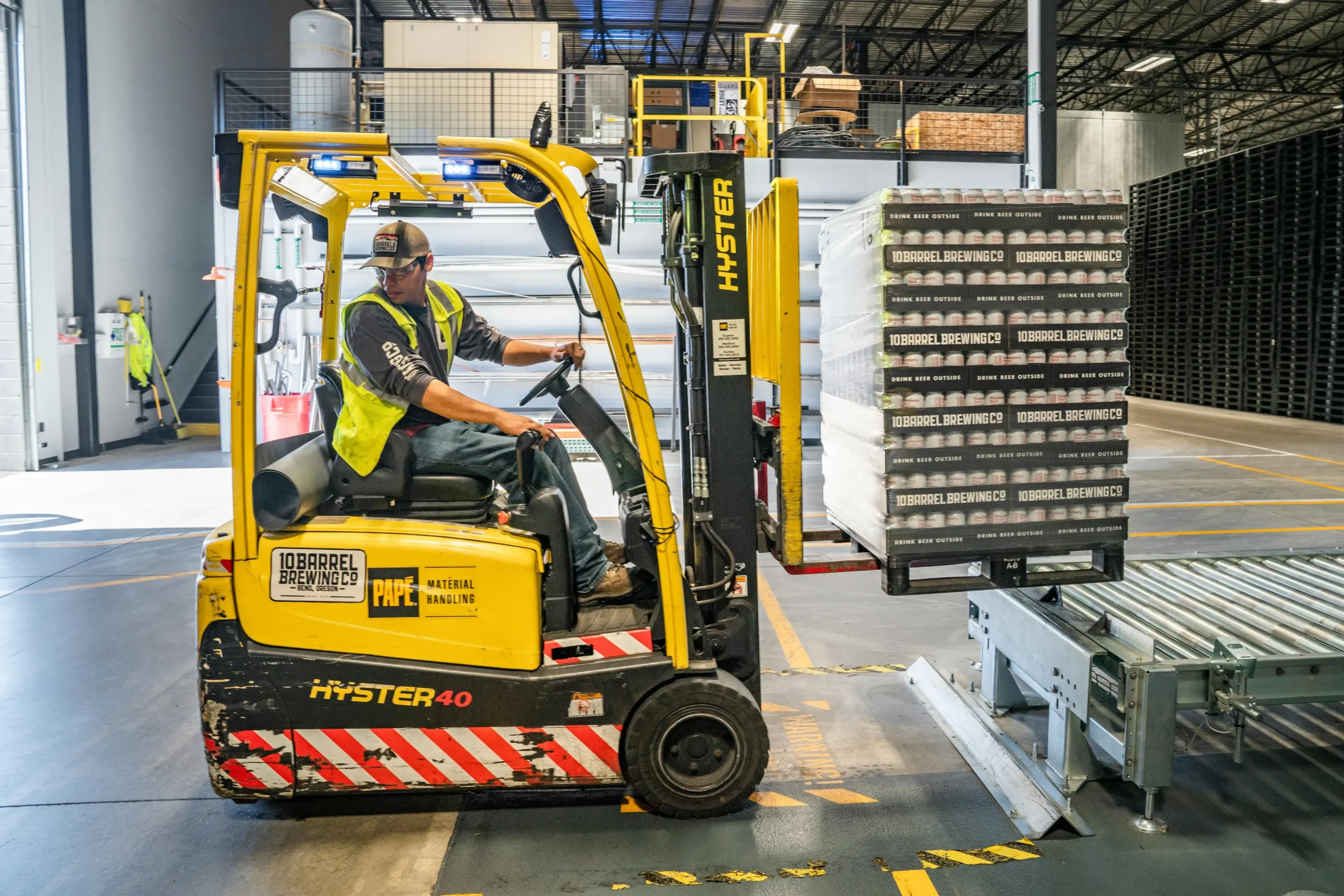 Heavy-duty forklift rental lifting large pallets at a busy construction or industrial job site